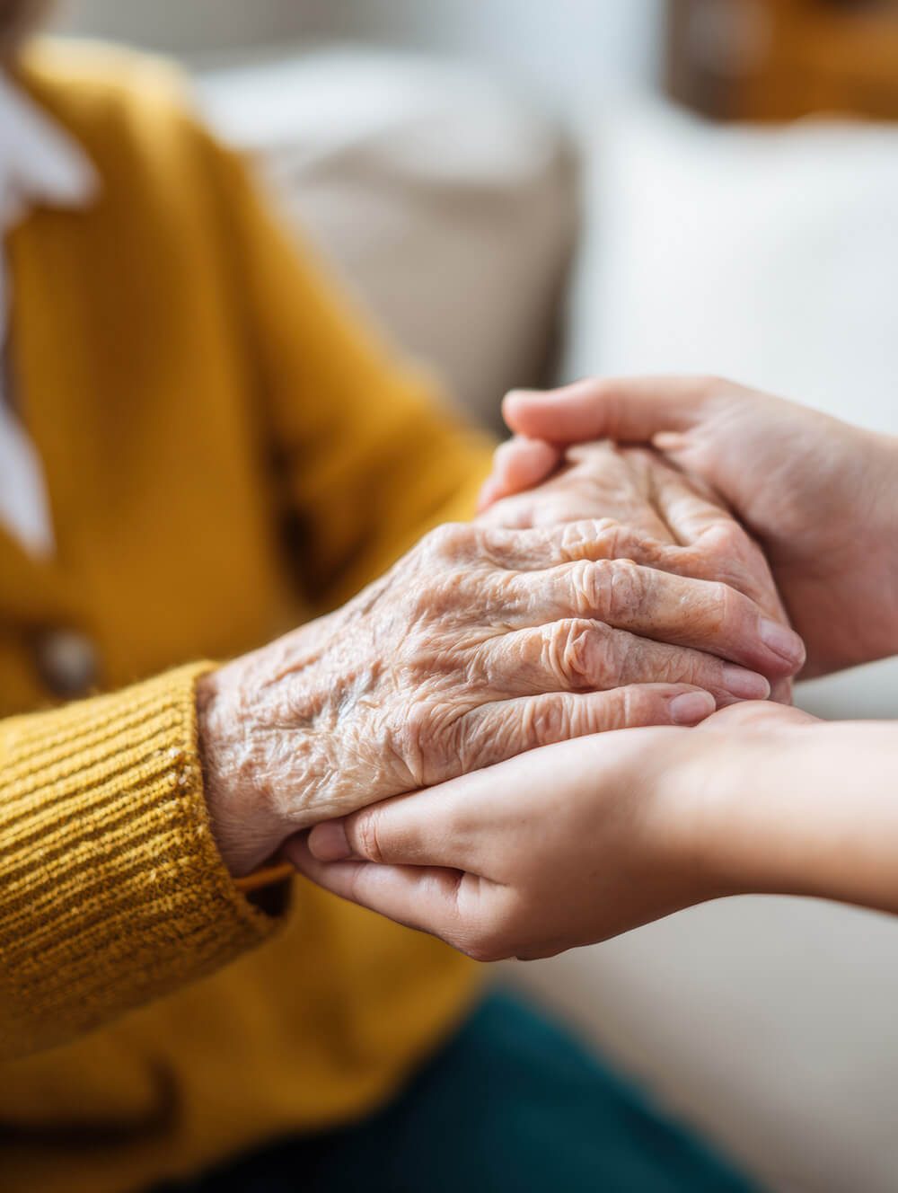 A younger person holding an older person’s hands